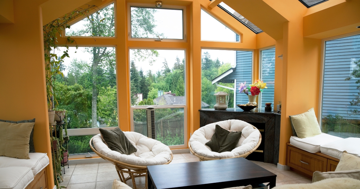Sunroom with orange wall, white couch and chairs