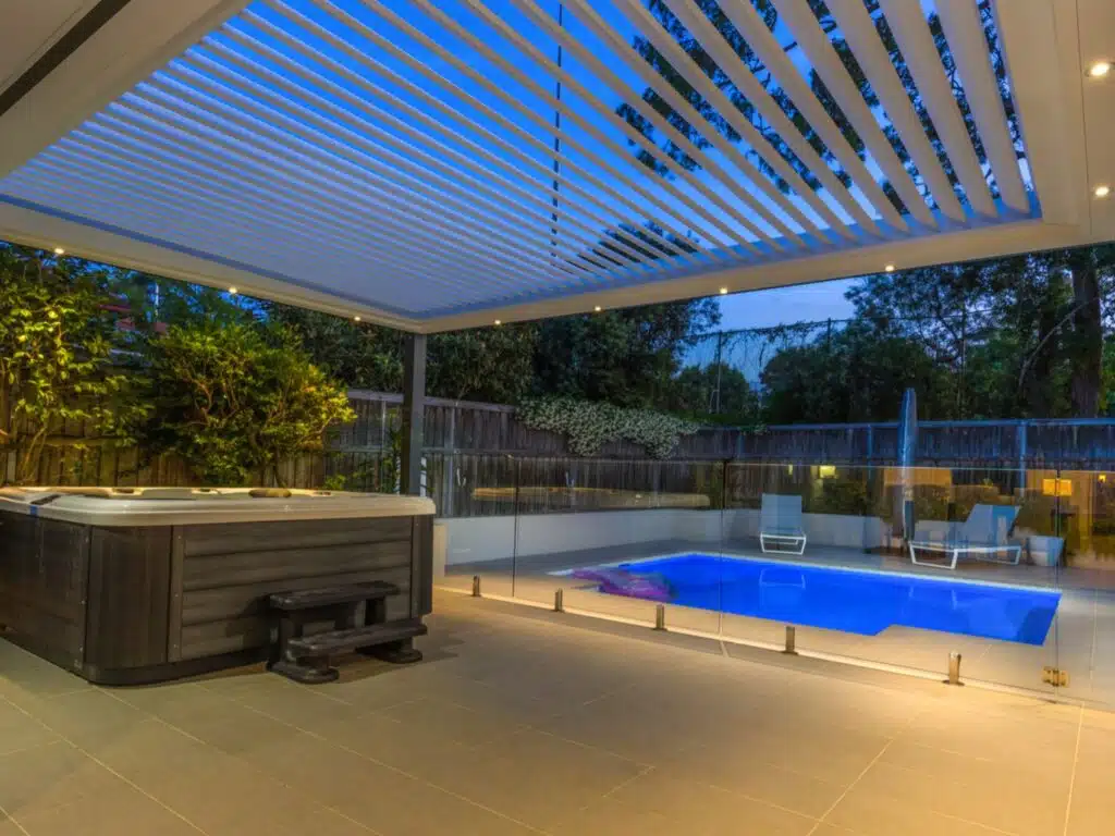 View of the pool area at dusk from underneath an Eclipse Opening Roof.