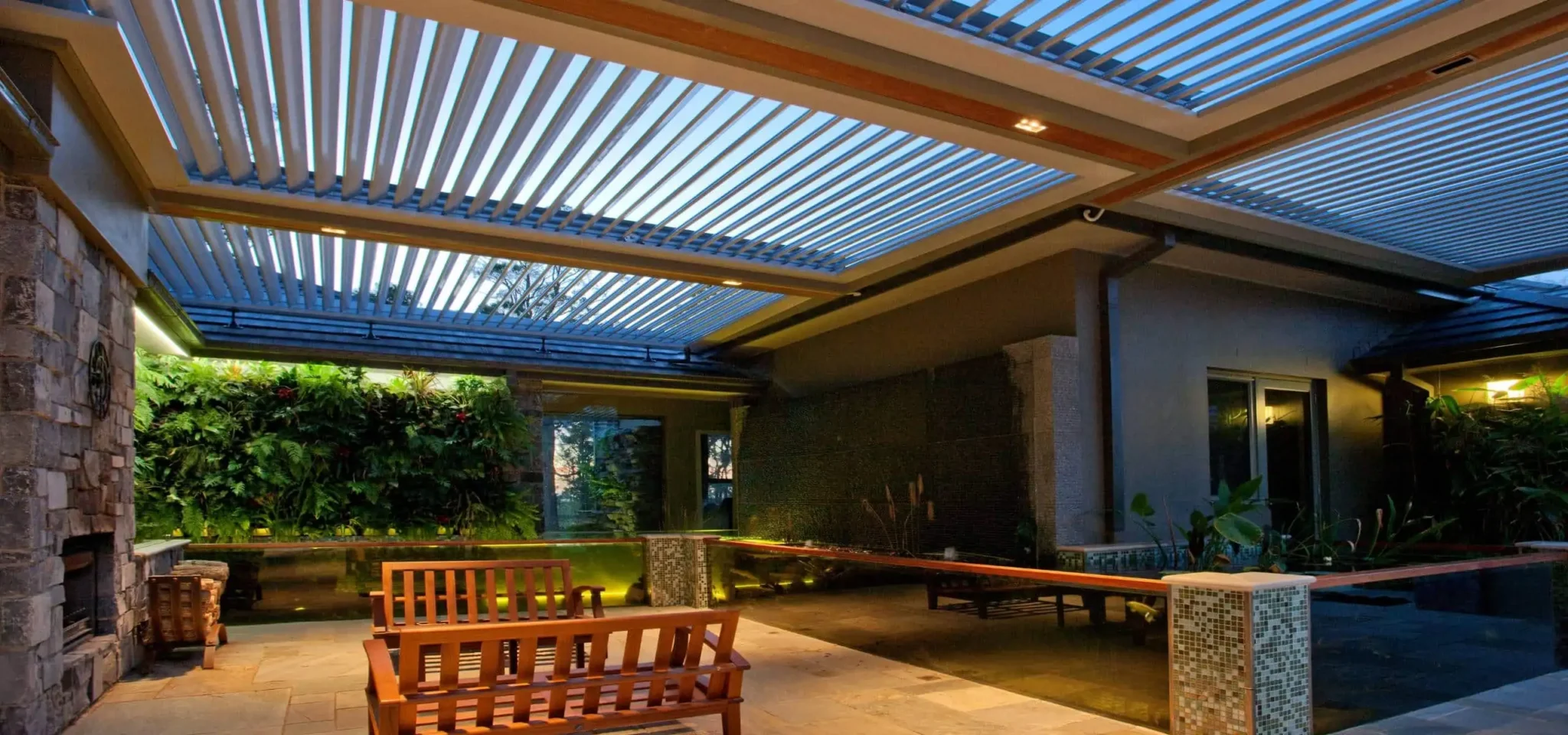 Outdoor entertaining area with louvre roof system constructed with multiple bays, LED lights, and remote control.