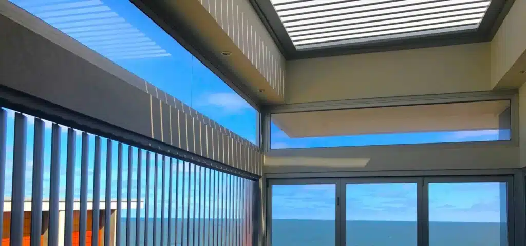 Sunroom with louvre roof and privacy screen slats overlooking the ocean.